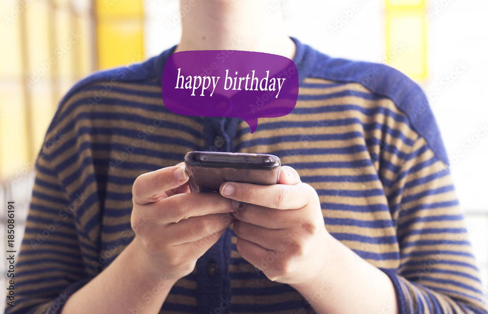 a young woman with a smartphone and the text message happy birthday in a chat bubble