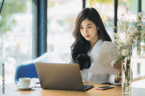 Young business woman using on the laptop while sitting at her working place. 