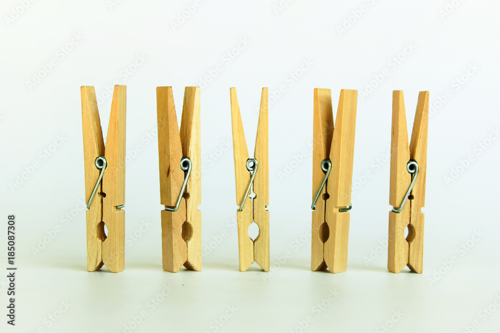 Brown wood clothespin, paper clip on white background Brown wood clothespin, paper clip on white background