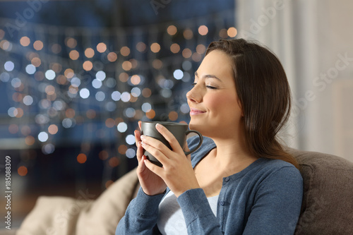Woman relaxing drinking coffee in the night at home