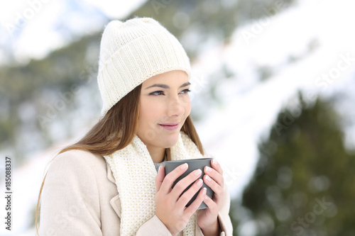 Woman looking away holding a coffee mug in winter