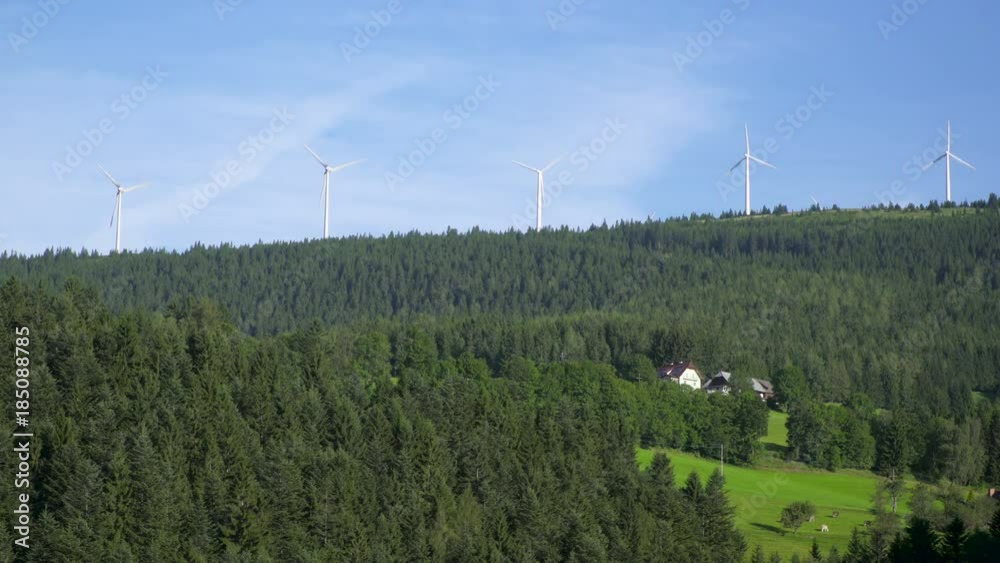 Spinning five aerogenerators in the Austrian Alps mountains and forest
