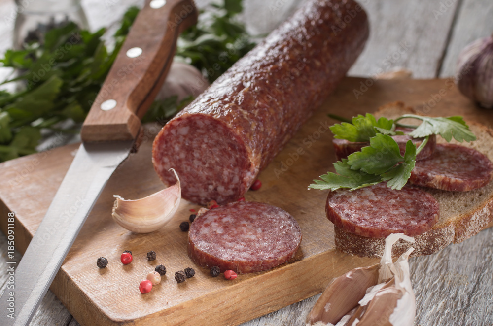 salami and bread on a wooden board salami and bread on a wooden board