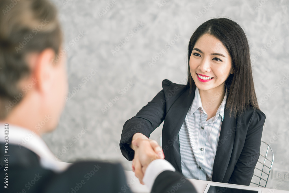 Two of business man and asian business woman shaking hands in the meeting for success and agreement to express teamwork/togetherness and cooperation concept Two of business man and asian business woman shaking hands in the meeting for success and agreement to express teamwork/togetherness and cooperation concept