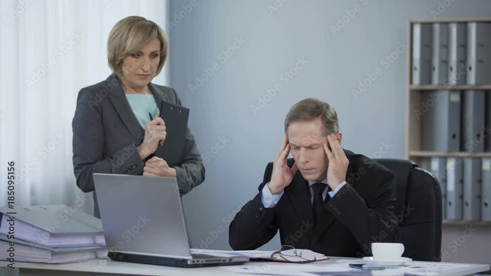 Upset stressed business man suffering from headache, meeting with secretary Upset stressed business man suffering from headache, meeting with secretary