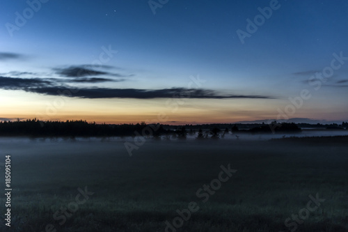 Fog in the meadow  forest and clouds after sunset