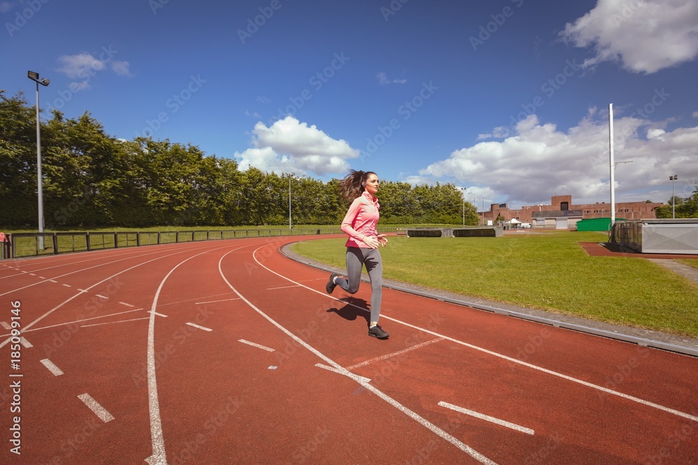 Fototapeta premium Woman jogging on a race track
