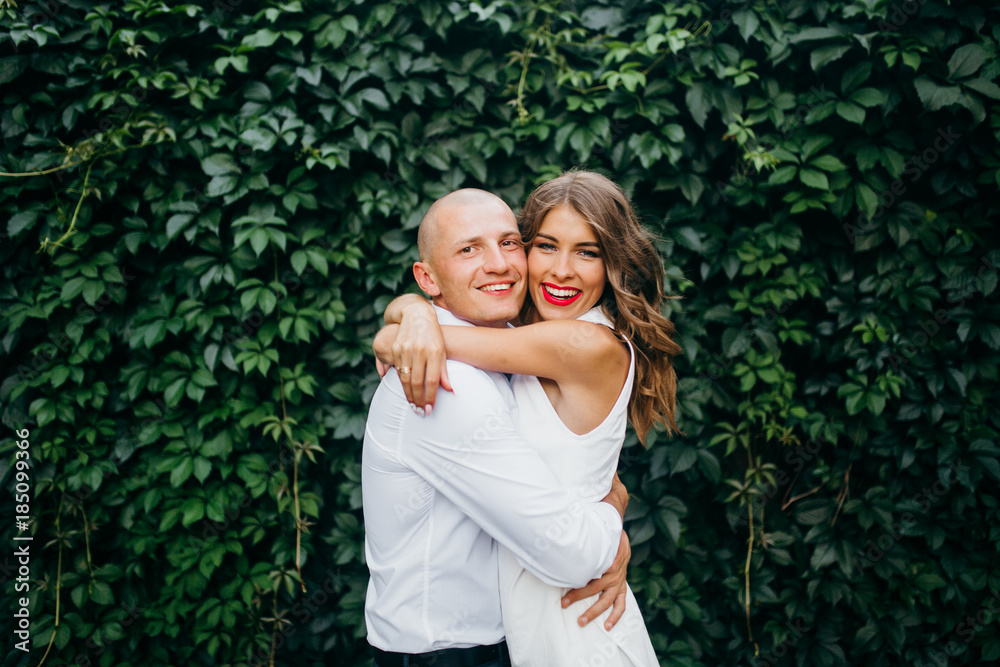 Young couple in white clothing near the plants Young couple in white clothing near the plants