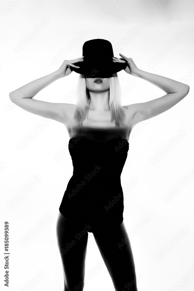 Fototapeta premium Beautiful blonde girl in black body and heels with visible shadow