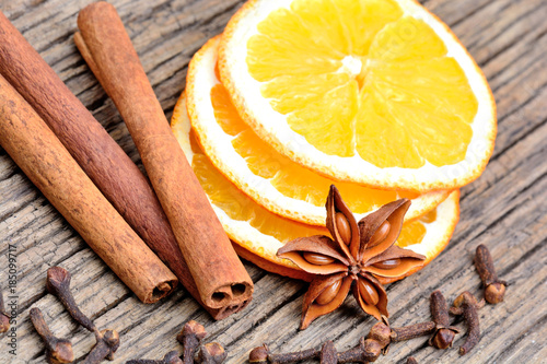 Slices of orange, cinnamon, cloves and anise star on table