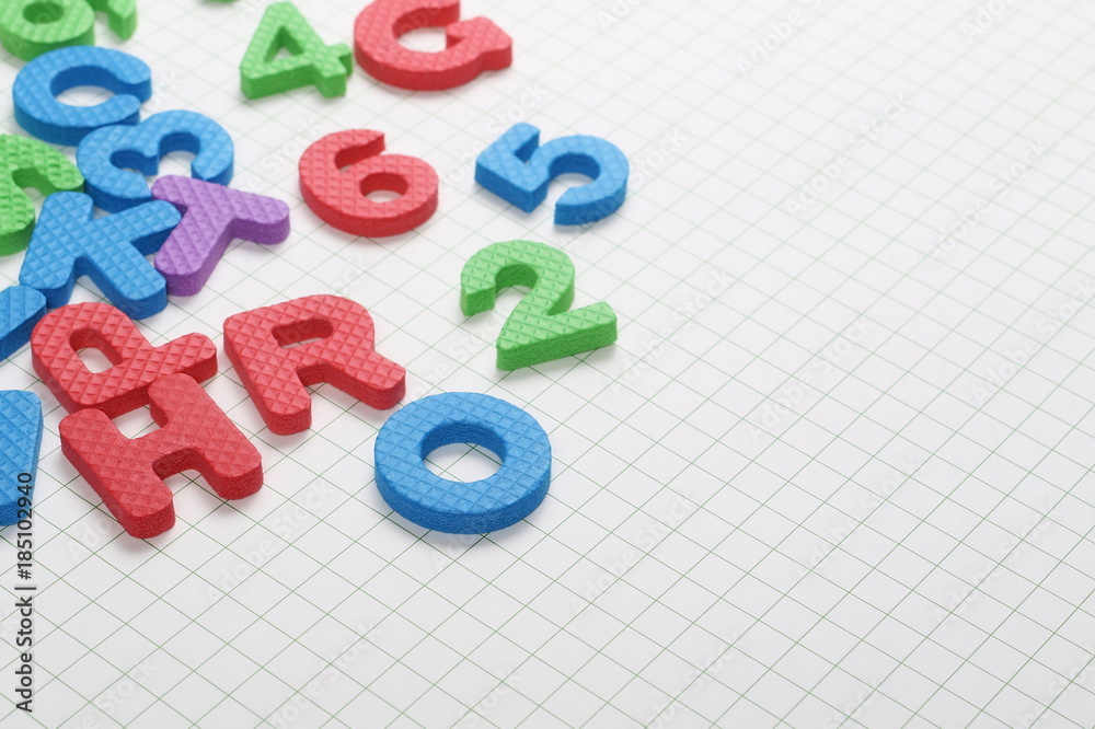 Naklejka premium Alphabet letters and numbers pile isolated on white checkered background