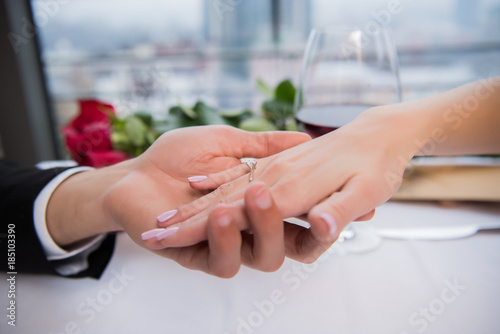 cropped shot of boyfriend holding fiances hand during romantic date in restaurant
