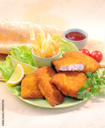 Breaded Fried fish with potato fries and tomato ketchup with lemon cherry tomato