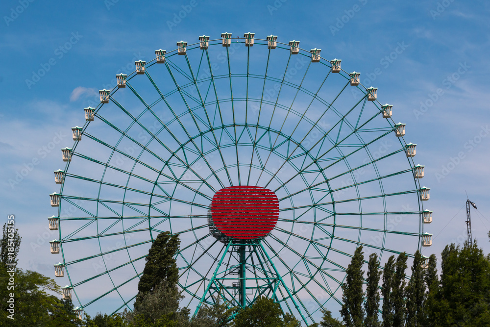Fototapeta premium Ferris Wheel with White Cabins againt Blue Sky