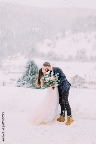 Winter love story. Beautiful couple in winter forest. Long-awaited meeting of two lovers. Young pretty pair of lovers. Winter. Date. A pair of lovers on a date in the mountains. 