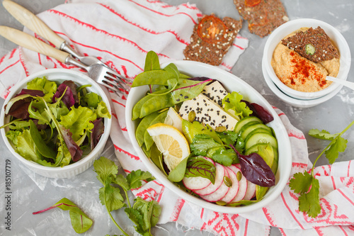 Green salad, buddha bowl with tofu, vegetables, hummus with flax crispbread.