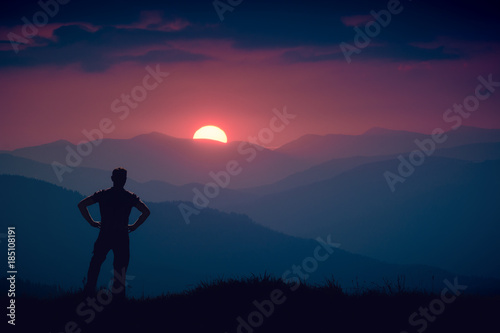 Silhouette of human standing on a hill