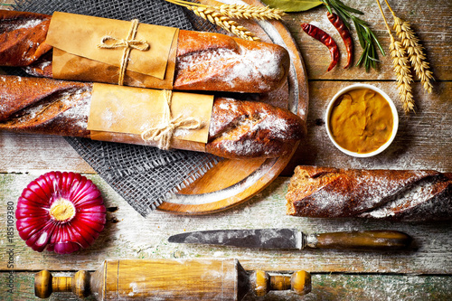 Bread and pastries in a composition with kitchen accessories on an old background