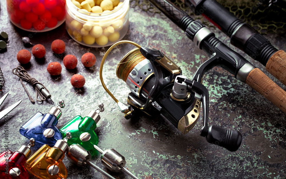 Fishing rods and spinnings in the composition with accessories for fishing on the old background on the table Fishing rods and spinnings in the composition with accessories for fishing on the old background on the table