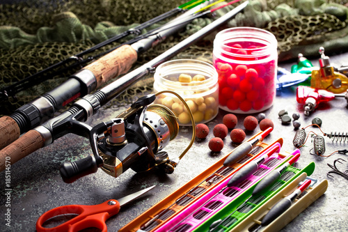 Fishing rods and spinnings in the composition with accessories for fishing on the old background on the table