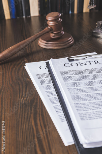 juridical contract on wooden table with hammer , law concept