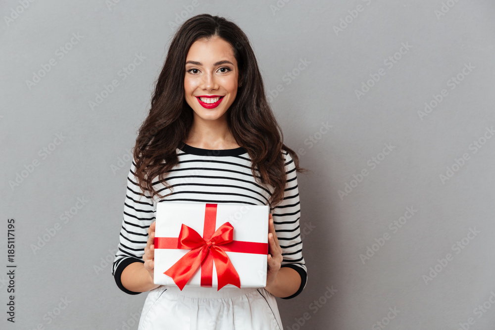 Fototapeta premium Portrait of a smiling girl holding present box