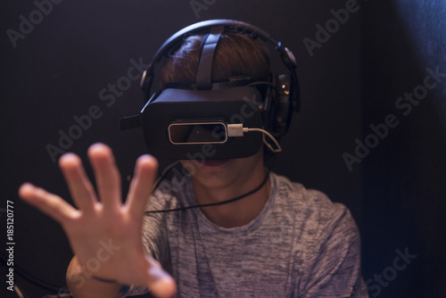 Teenager boy playing with 3d glasses in virtual reality videogame