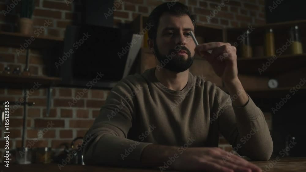 Healthy lifestyle. Close up of young thoughtful man looking at the cigarette and breaking it while expressing optimism Healthy lifestyle. Close up of young thoughtful man looking at the cigarette and breaking it while expressing optimism