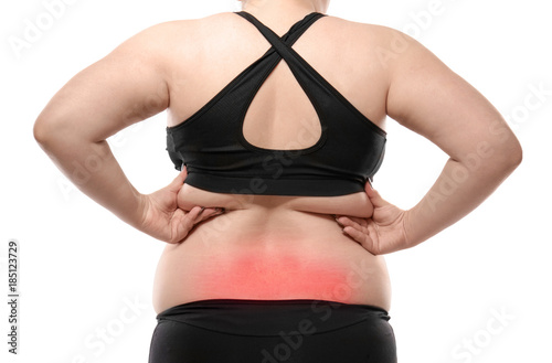 Woman touching fat on her back against white background. Weight loss concept