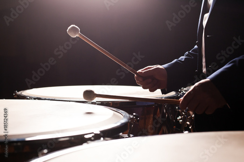 Drum sticks striking in timpani in dark tones 