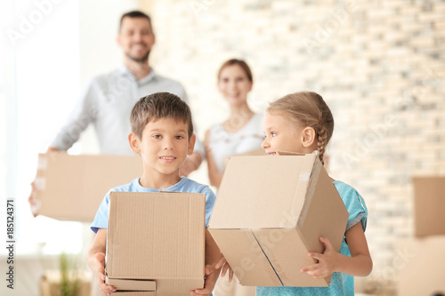 Happy family with cardboard boxes in new flat © Africa Studio