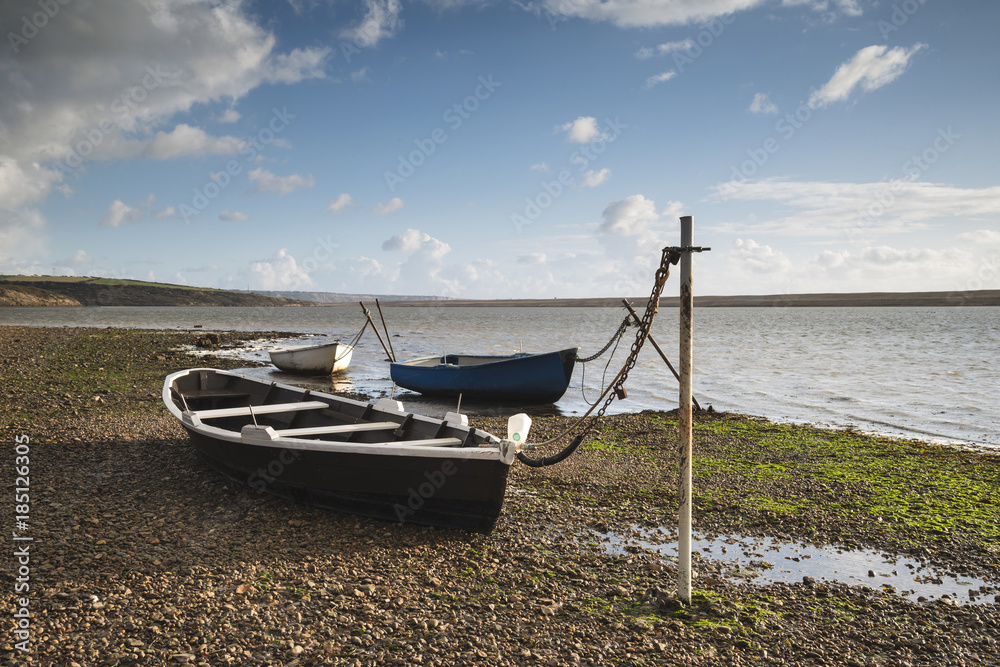 Beautiful vibrant sunset landscape image of boats moored in Fleet Lagoon in Dorset England Beautiful vibrant sunset landscape image of boats moored in Fleet Lagoon in Dorset England