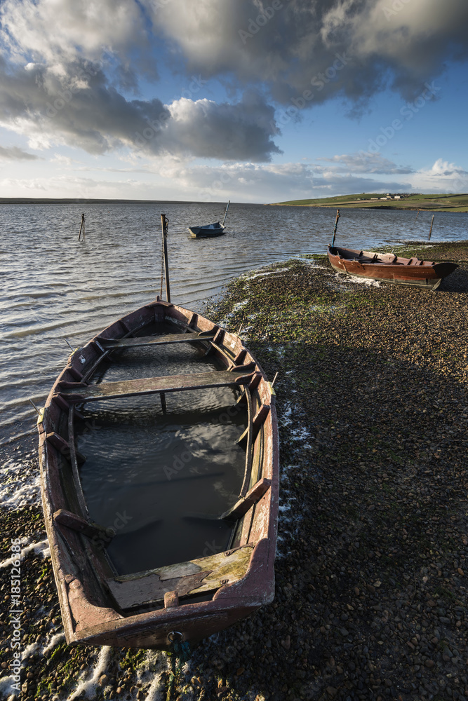 Beautiful vibrant sunset landscape image of boats moored in Fleet Lagoon in Dorset England Beautiful vibrant sunset landscape image of boats moored in Fleet Lagoon in Dorset England