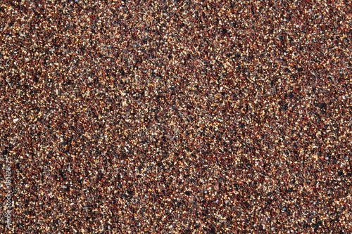 Texture of red, yellow and black coarse sand grains