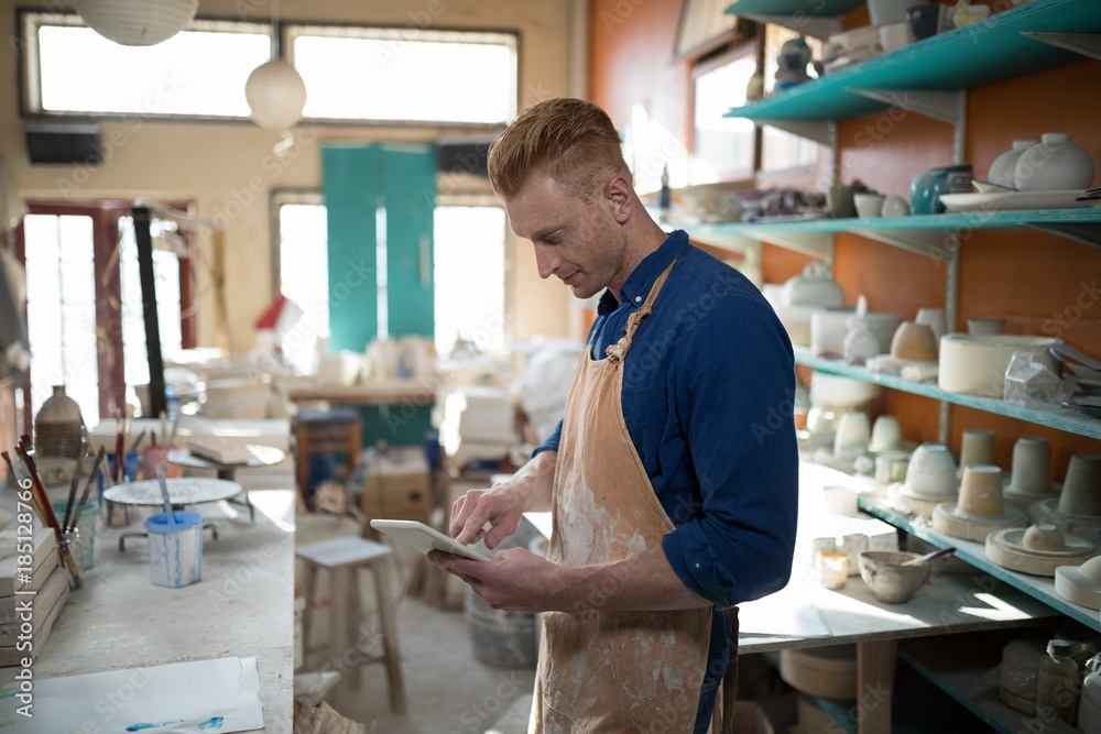 Fototapeta premium Male potter using digital tablet
