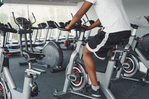 Man's legs on exercise bike in fitness club, healthy lifestyle