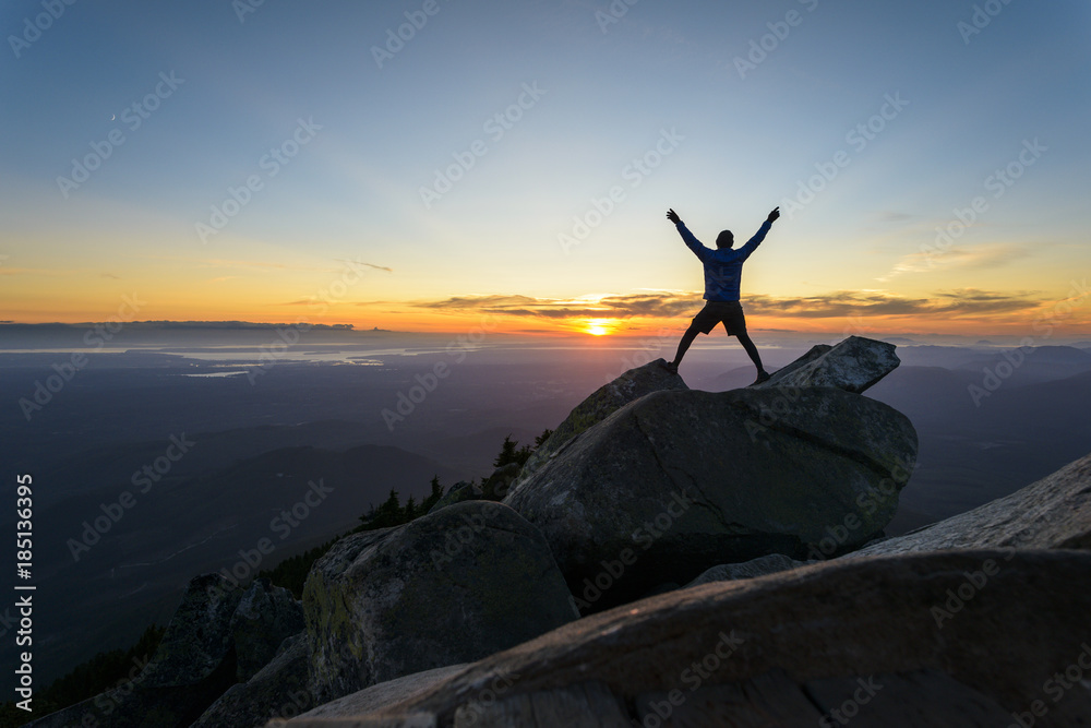 Silhouette man with arms raised standing on rocks against sky at Mount Pilchuck State Park during sunset Silhouette man with arms raised standing on rocks against sky at Mount Pilchuck State Park during sunset