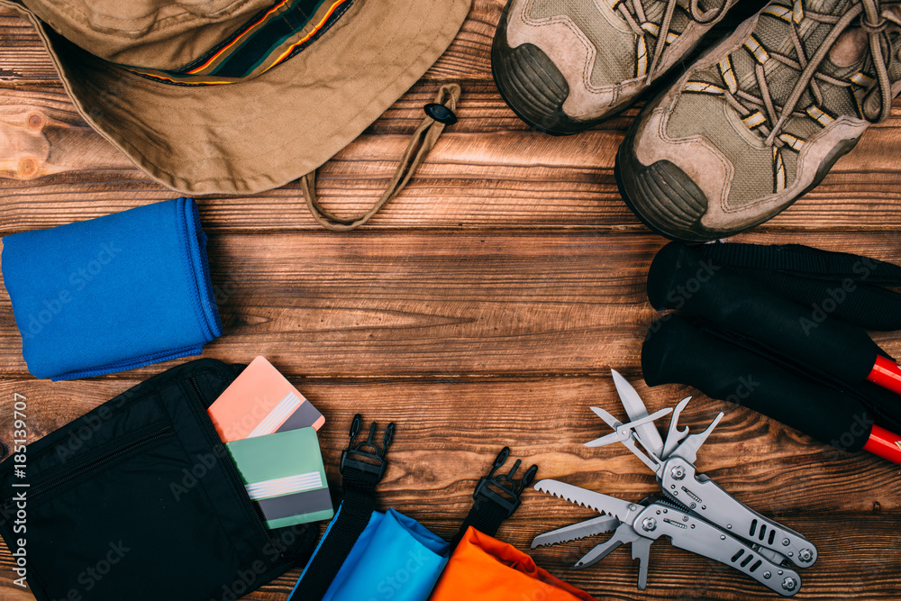 Top view of equipment for hiking and travel on wooden table