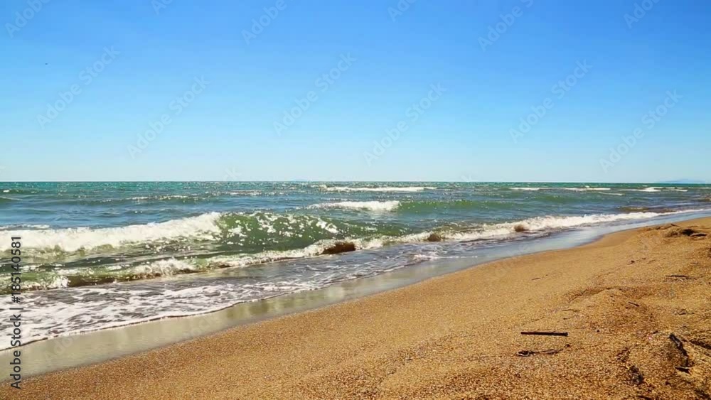 Waves on a beach on a sunny day in the Mediterranean Sea in Tuscany, Italy Waves on a beach on a sunny day in the Mediterranean Sea in Tuscany, Italy