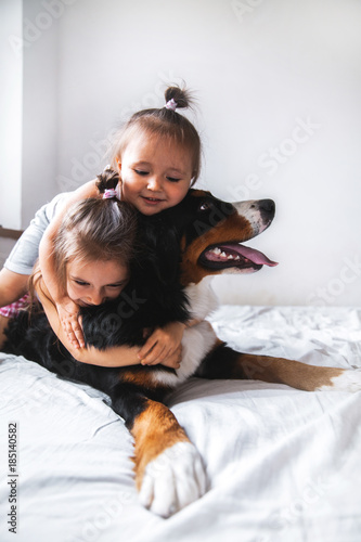 little girl In the bed stoey playing with a dog. animals, recreation, game, family