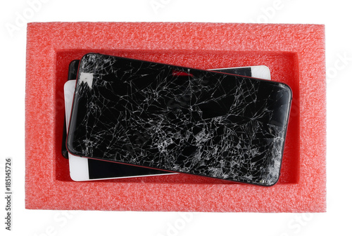 Broken defective smartphones are waiting for their repair in a plastic red industrial box photo