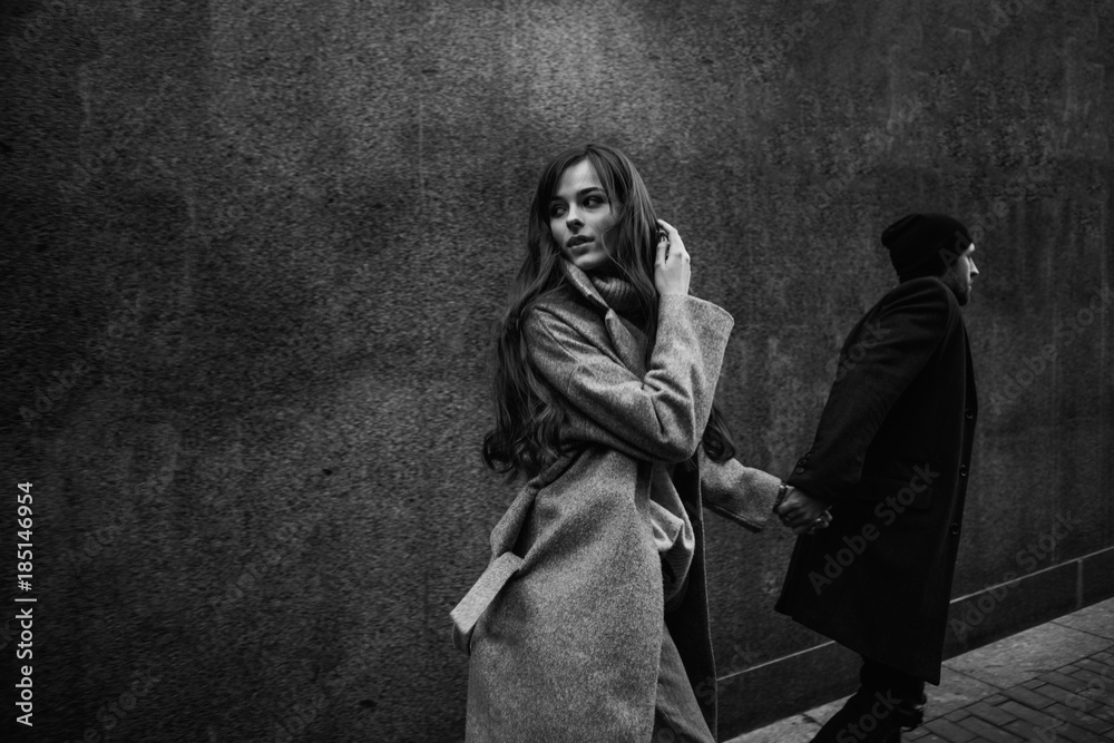 Naklejka premium Beautiful couple in stylish clothes in gray tones, city