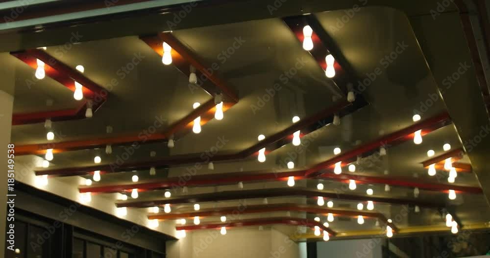 Theatre lights blinking on the ceiling of a city marquee at night.  	