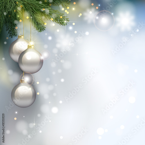 Holiday Christmas light background with fir tree branches and shining evening balls.