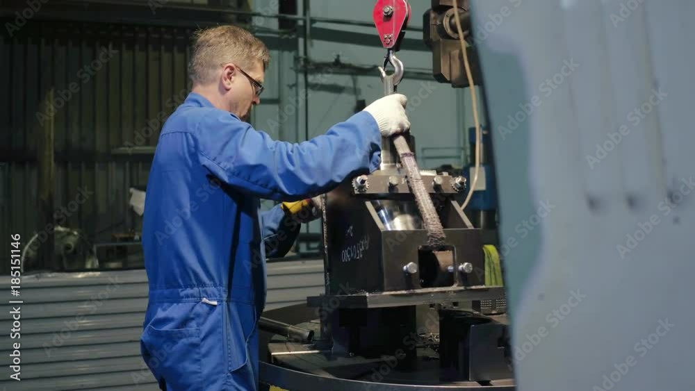 Factory employee put metal detail in professional metalworking lathe for test Factory employee put metal detail in professional metalworking lathe for test