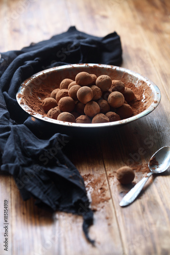 Vegan Chocolate Glazed Truffles in a silver plate, on wooden background.