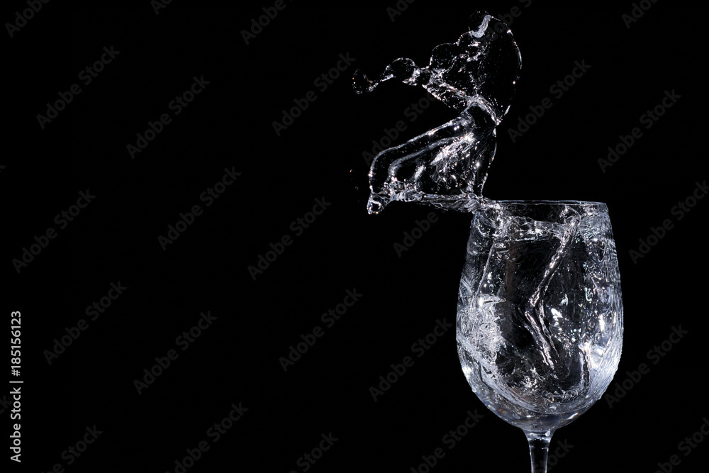 Water splash in a glass on a black background Water splash in a glass on a black background