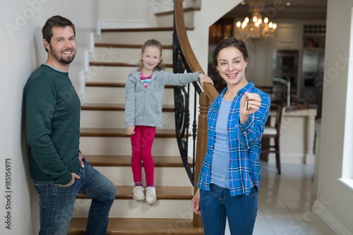 Woman holding house key while sitting on stairs