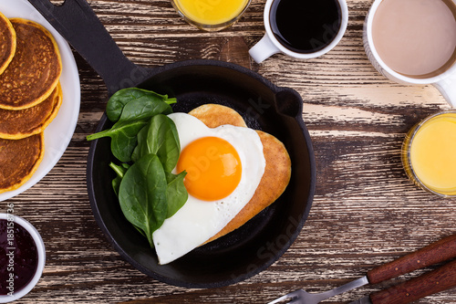 Valentine's day breakfast or brunch with  heart shape fried egg in cast iron skillet