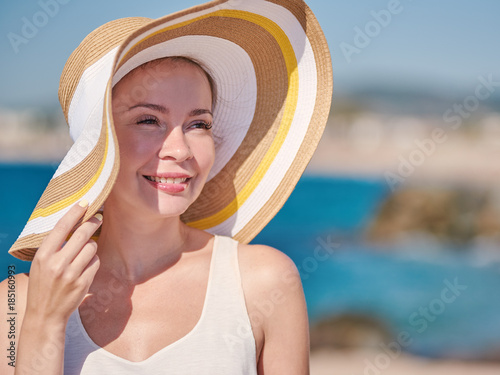 Woman in bonnet hat relaxing on the beach.